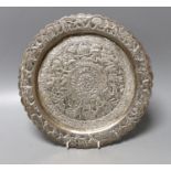 A Indian embossed white metal shallow dish, decorated with animals and foliage amid scrolls, 25.3cm,