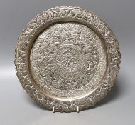 A Indian embossed white metal shallow dish, decorated with animals and foliage amid scrolls, 25.3cm,