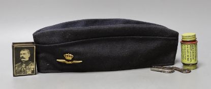 An Airforce cap. a Kitchener commemorative matchboc, a WWI uniform repair kit and a bincoluar lens