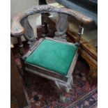 A Victorian carved oak corner elbow chair