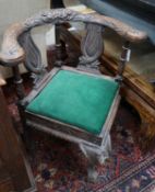 A Victorian carved oak corner elbow chair