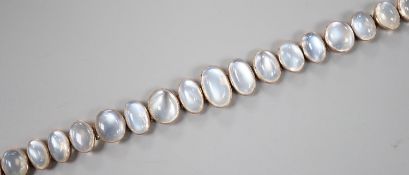 An Edwardian white and yellow metal, graduating oval cabochon moonstone set bracelet, 18cm, gross