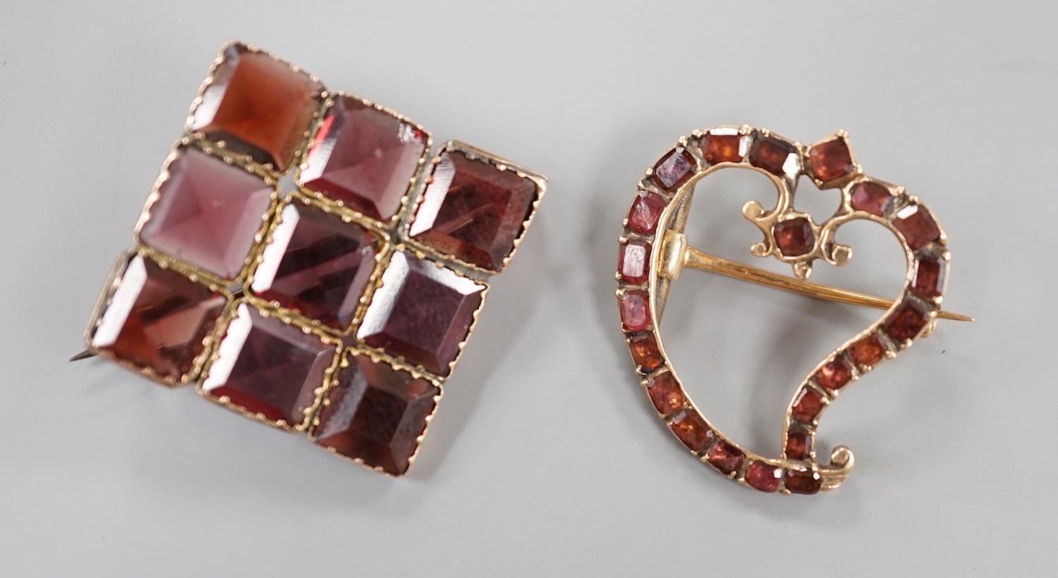 Two Victorian yellow metal and garnet set brooches, square and stylised heart shape, largest 32mm.