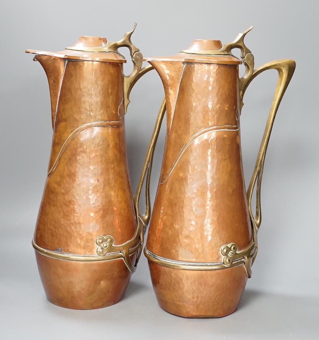 A pair of German or Austrian Jugendstil copper and brass jugs, 38cm