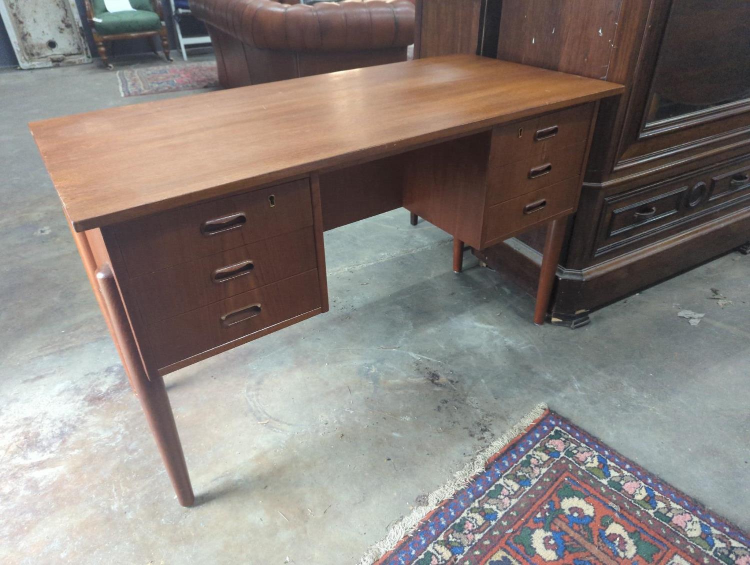 A mid century Danish teak kneehole dressing table of rectangular concave form, width 116cm, depth