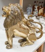 A pair of large brass lion models. 39cm