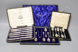 A cased set of twelve Edwardian silver teaspoons with tongs, a cased set of six tea knives and a