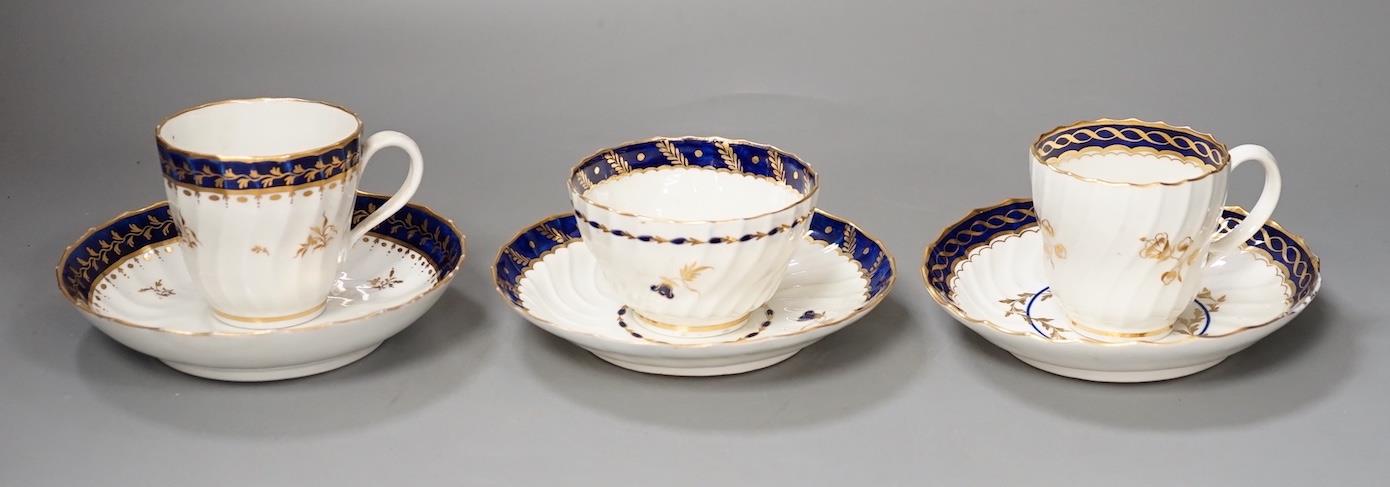 Three flight Worcester shankered teawares two coffee cup and saucers with blue borders and a teabowl