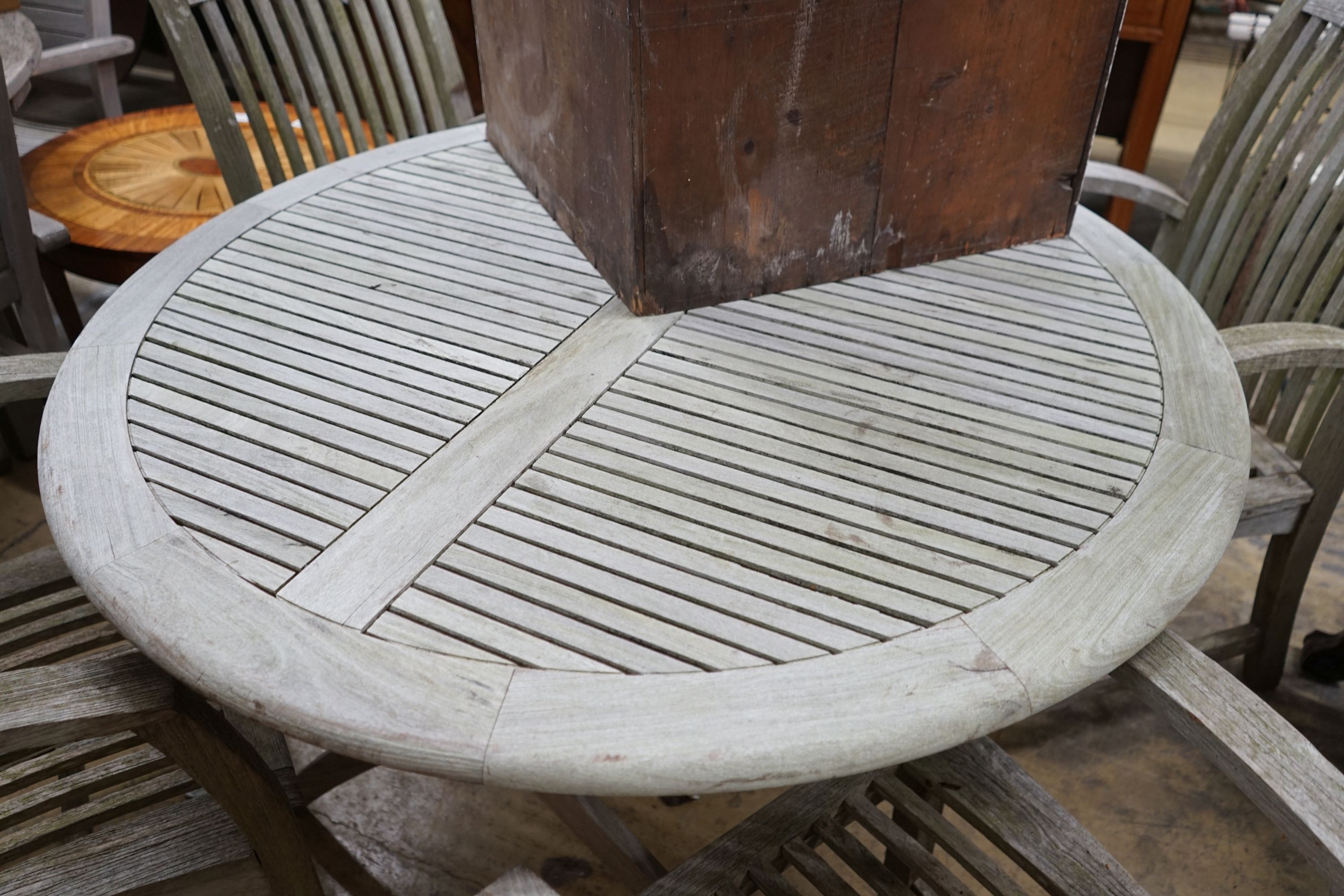 A circular weathered teak folding garden table, diameter 120cm, height 74cm and four teak chairs - Image 3 of 3