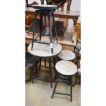An industrial style circular adjustable table, diameter 60cm, together with three matching stools