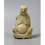 A carved soapstone figure of a seated smiling Buddha - 8cm tall