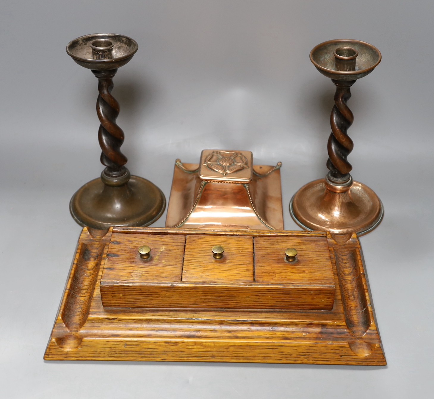 A copper Arts & Crafts inkwell, a pair of A Jones turned candlesticks and an early 20th century