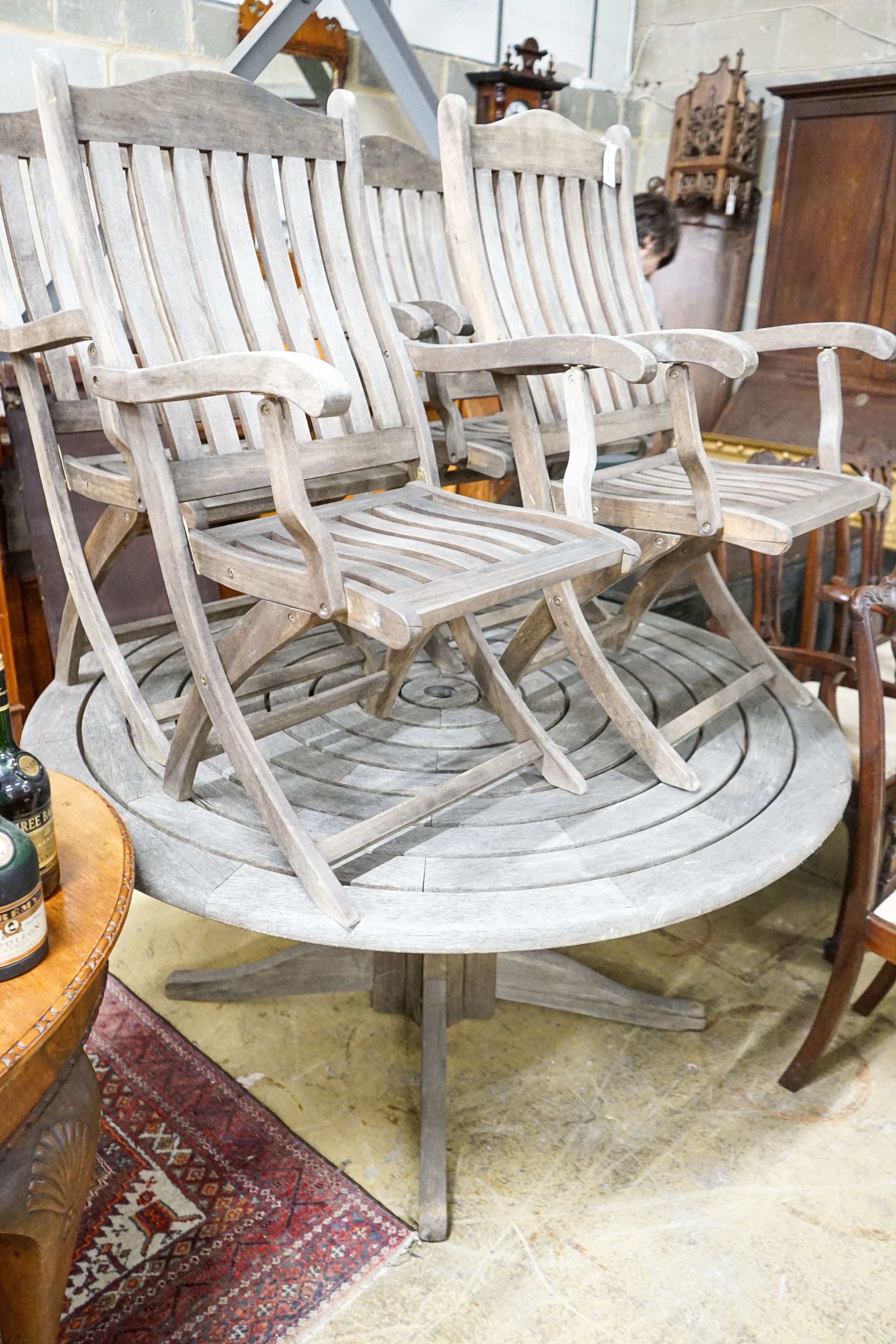 An Alexander Rose circular weathered teak garden table, diameter 144cm, height 71cm, (no bolts)