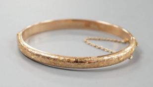 An engraved hollow 9ct gold bangle, 7.6 grams.