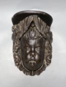 A 17th/18th century carved oak cherub head corbel, 24.5cm tall