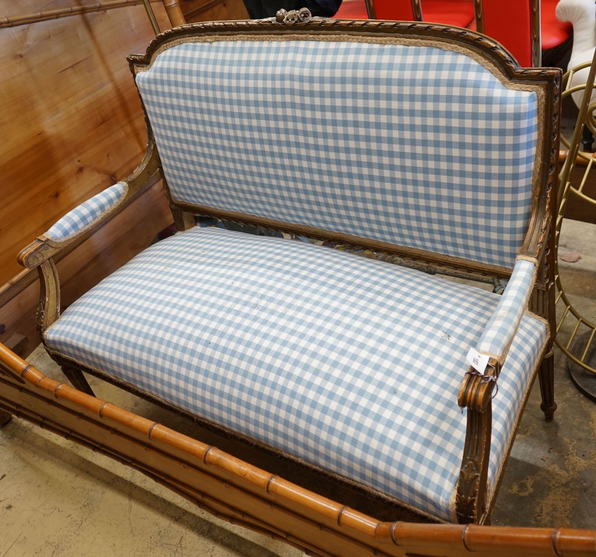 A 19th century French carved giltwood settee recently re-upholstered in blue gingham fabric, width