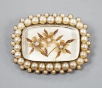 A 19th century yellow metal and seed pearl brooch, with glazed floral motif, 31mm, gross weight 6.