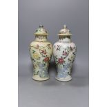 A pair of 19th century Chinese famille rose vases and covers - 27cm tall