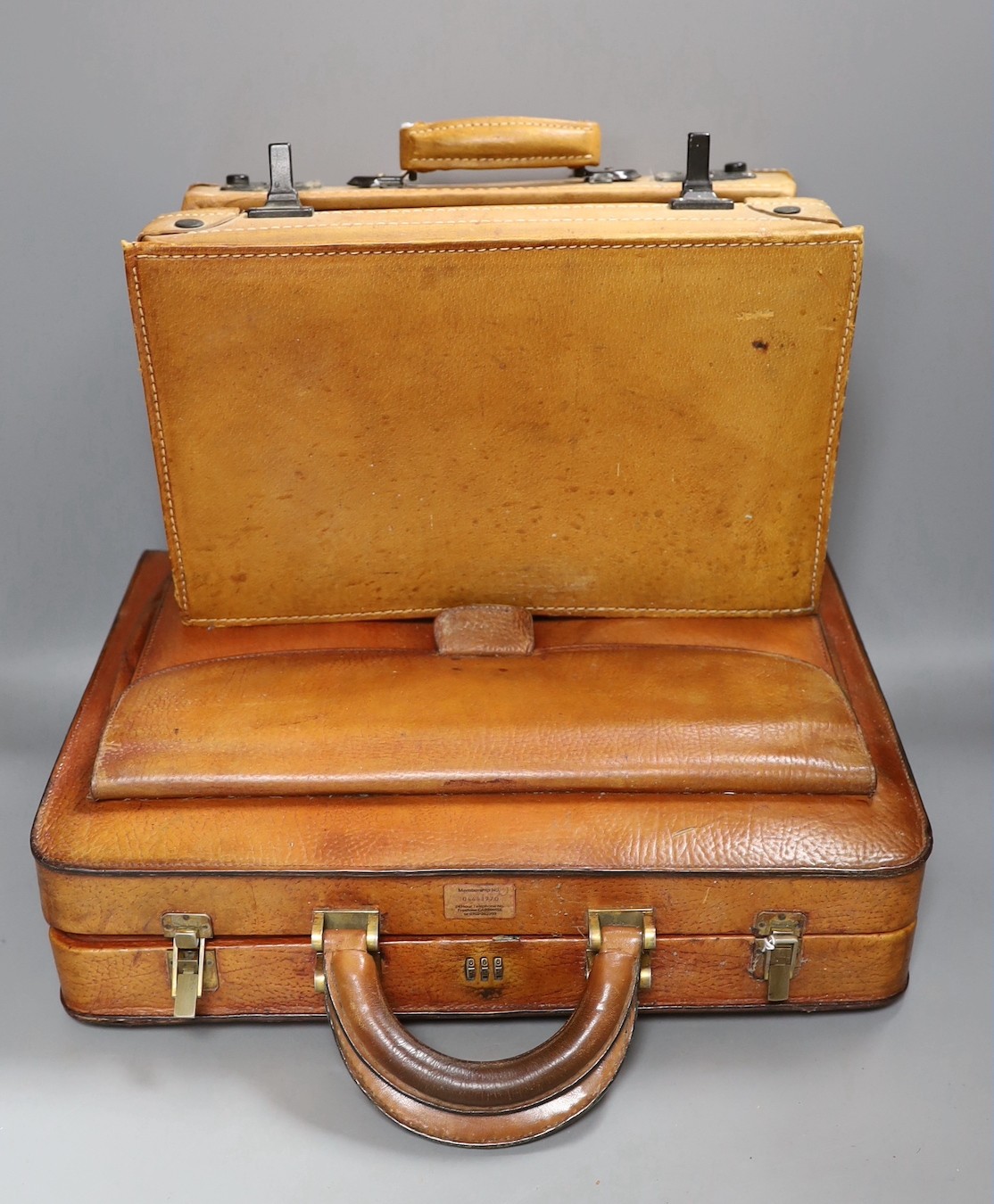 A vintage brown leather briefcase with integrated lock system, together with another Italian