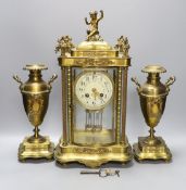 An early 20th century French brass four glass mantel clock garniture with key and pendulum, 41cm