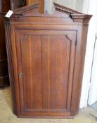 A George III oak hanging corner cabinet, width 85cm, depth 47cm, height 127cm