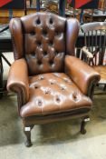 A Victorian style buttoned brown leather-upholstered wing armchair, width 77cm, depth 62cm, height