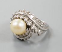 A white metal single stone cultured pearl and diamond cluster set scroll dress ring, size Q, gross