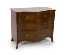 A George III mahogany serpentine chest, with brushing slide and three graduated long drawers, on