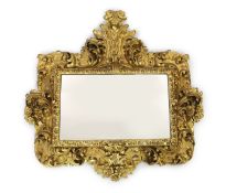 A mid 19th century Florentine ornately carved giltwood wall mirror, of rectangular cartouche form