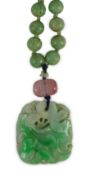 A Chinese jadeite pendant and jadeite beads, 19th century, the pendant carved in relief with a