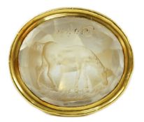 A large antique style gold and intaglio white stone set ring, the stone carved with a horse and