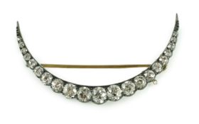 A Victorian, gold, silver and graduated twenty one stone diamond set crescent brooch, the largest
