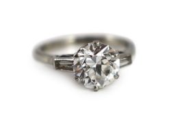 A mid 20th century platinum and single stone diamond ring, with trapeze cut diamond set shoulders,