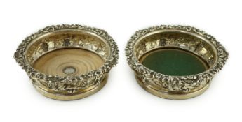 A pair of George IV silver mounted wine coasters, by S.C. Younge & Co, embossed with fruiting vine