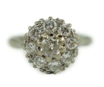 An 18ct white gold and nine stone diamond flower head cluster ring, the central stone