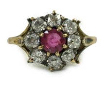 An antique gold, ruby and old cut diamond set circular cluster ring, size K, gross 4.6 grams.Some