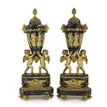 A pair of Louis XVI style ormolu mounted green marble urns with fixed lids and cherub and eagle