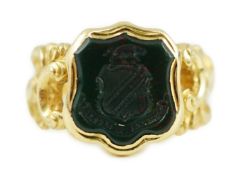 A 19th century gold and bloodstone set intaglio ring, carved with crest and motto, the shank with