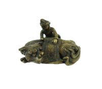 A Chinese bronze ‘Buddhist lion’ scroll weight, 17th/18th century, cast as a recumbent caparisoned