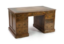 A late Victorian Gillow & Co. walnut pedestal desk, with gilt green skiver and an arrangement of