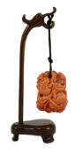 A good Chinese coral ‘fruit and bats’ pendant, 19th century, carved in high relief and open work