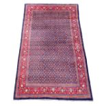 A North West Persian blue ground carpet, with central field of stylised floral motifs, multi-