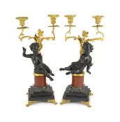A pair of Louis XVI style bronze and ormolu two light candelabra, each with seated putto stem and