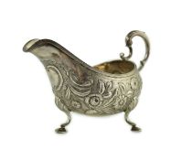 A George III Irish silver sauceboat, by Matthew West, embossed with flowers and vacant cartouche, on