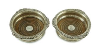 A pair of George IV silver wine coasters by Benjamin Smith III, with gadrooned and shell border, the