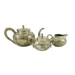 A 19th century Chinese Export silver three piece tea set by Cumshing? decorated with birds amid