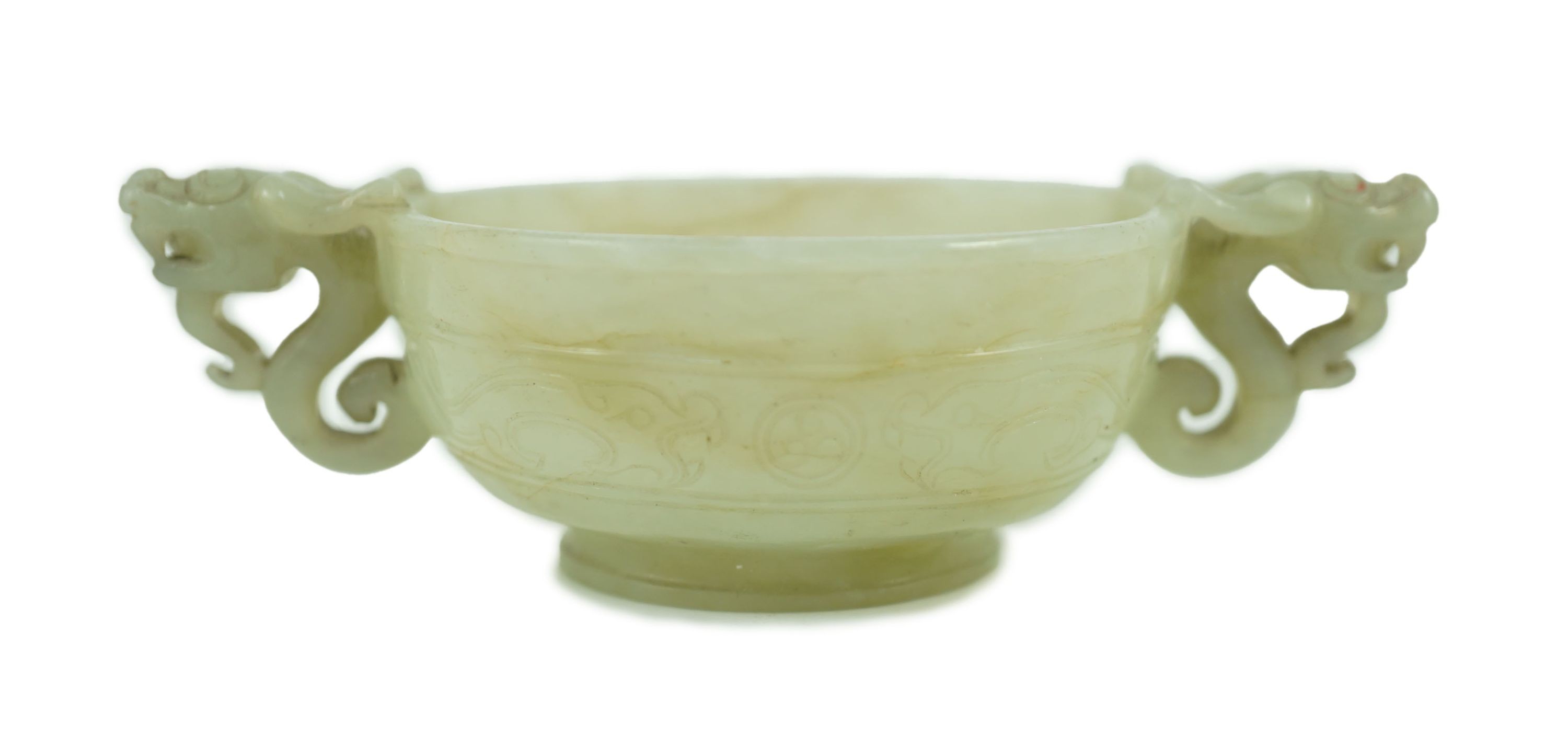 A Chinese pale celadon jade two handled ‘chilong’ cup, 17th/18th century, with a pair of carved