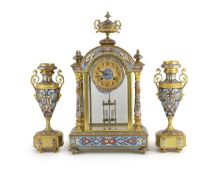 An early 20th century French ormolu and champleve enamel clock garniture, the mantel clock of