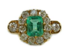 An 18ct gold, emerald and diamond octagonal cluster ring, with single emerald cut central stone