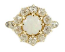 An early 20th century gold, white opal and diamond set circular cluster ring, with graduated diamond